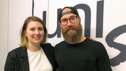 Ein junger Mann und eine junge Frau lächeln in die Kamera.