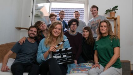 Gruppenfoto, Lachende Menschen mit Filmklappe