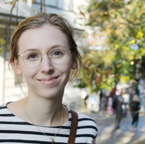 Eine junge Studentin lächelt in die Kamera.