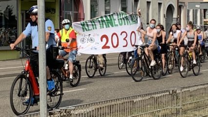 Fahrradfahrer mit Banner "Klimaneutralität 2030"