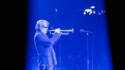 Sven Regener steht auf der Bühne und spielt Trompete