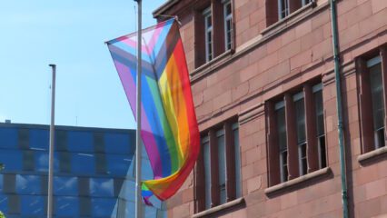 Eine Regenbogenflagge vor dem Universitätsgebäude in Freiburg